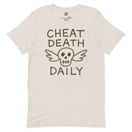 A blonde woman with loose, wavy hair is sitting in the back seat of a car, wearing a black t-shirt that reads “CHEAT DEATH DAILY” in bold, white capital letters across the chest. The shirt is part of the Highway Division collection and has a minimalist, rebellious aesthetic. The woman is facing slightly toward the window, with natural light highlighting her hair and the texture of the shirt. She has a confident, calm expression, exuding a sense of edge and defiance. The interior of the car is slightly
