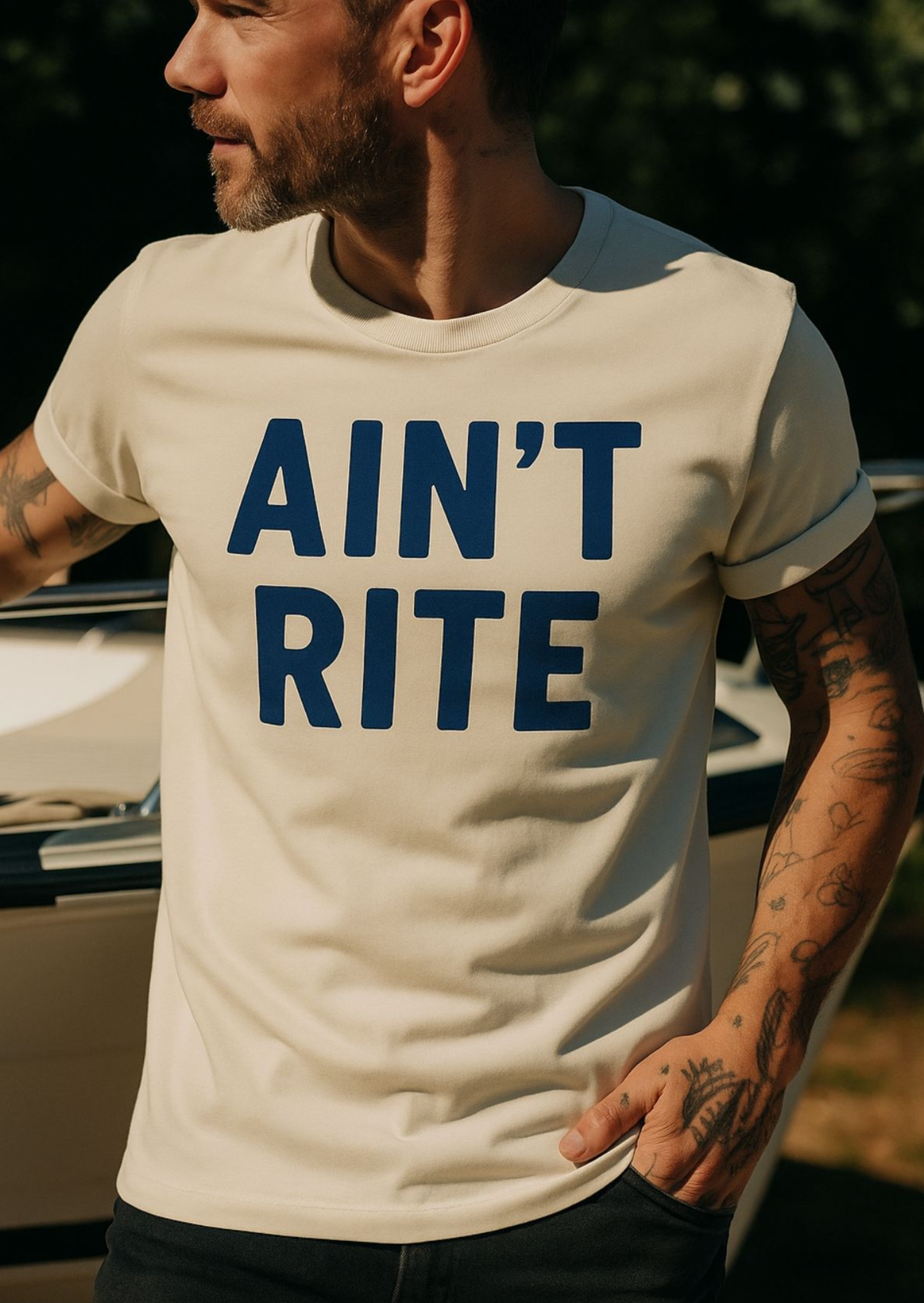 A white short-sleeve t-shirt from Highway Division is displayed against a neutral background, either laid flat or worn by a model with a casual, street-style attitude. The shirt features a bold black front print that reads “Ain’t Right” in large, all-caps or stylized lettering across the chest. The text is the focal point of the design, capturing a rebellious, unapologetic tone that reflects the Highway Division brand’s raw and anti-mainstream aesthetic. The shirt has a clean, minimal layout 