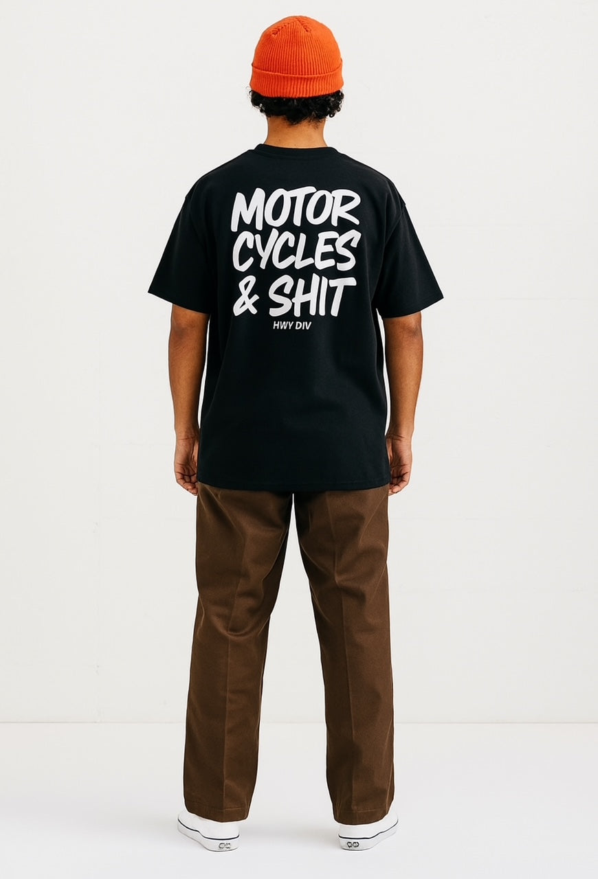Person wearing a black t-shirt with 'Motor Cycles & Shit' text on the back, standing against a white background.