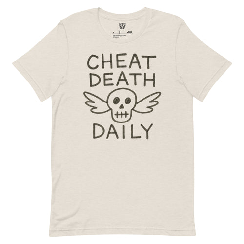 Natural-colored t-shirt with bold black text on the front that reads "Cheat Death Daily." The shirt has a minimalist design and is made by Highway Division, featuring a relaxed, unisex fit and a raw, rugged aesthetic.