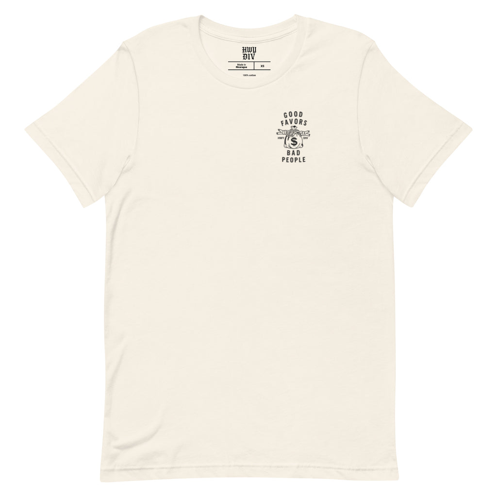 Model wearing vintage white Highway Division t-shirt with bold "GOOD FAVORS BAD PEOPLE" front print; rebellious streetwear with a gritty, anti-mainstream aesthetic.
